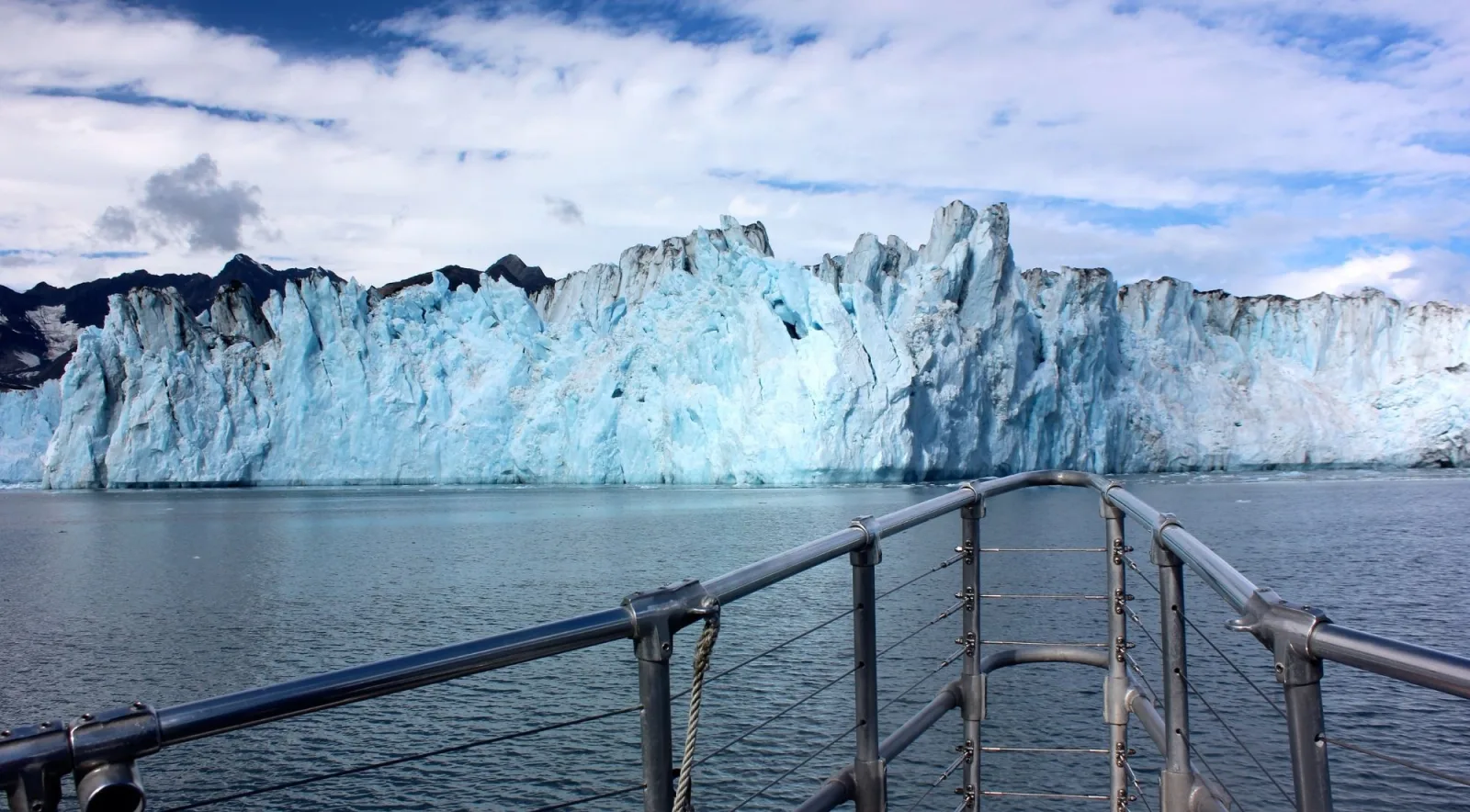 A glacier face photographed over the deck railing of a Prince William Sound tour boat